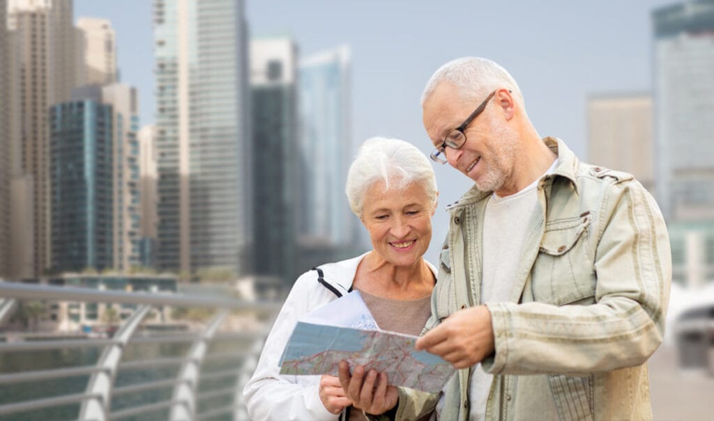 Retired couple reading a map with the Dubai skyline behind them, illustrating the UAE retirement visa requirements